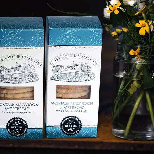 Two boxes of Blake's Mother's Cookies Montauk Macaroon Shortbread cookies next to a vase of country flowers