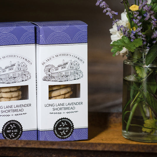 Two boxes of Lavender shortbread cookies next to a vase of flowers