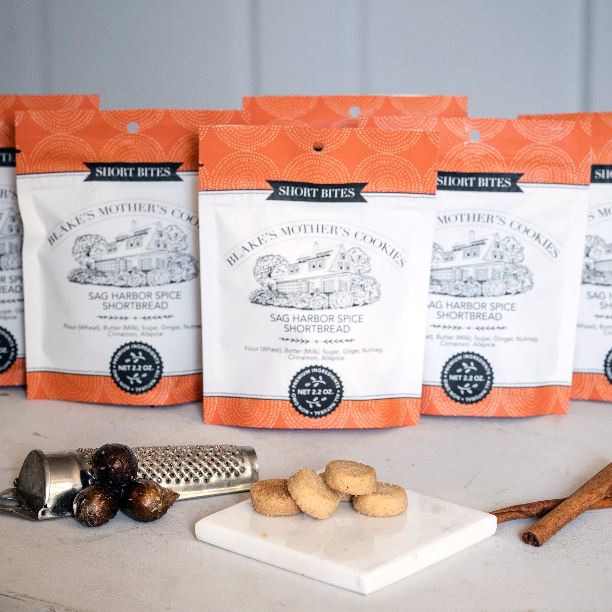 Six pouches of Sag Harbor Short Bites with spices and shortbites on a marble plate.